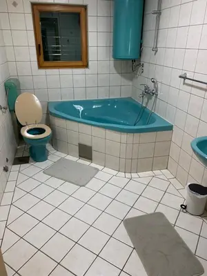 a bathroom with a blue tub and a toilet at Vista Dubica in Bosanska Dubica
