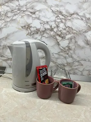 a coffee maker and two cups on a counter at Apartman Mila Prnjavor in Prnjavor
