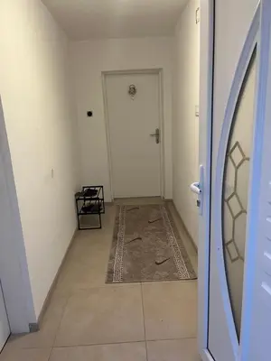 an empty hallway with a white door and a rug at Apartman Mila Prnjavor in Prnjavor