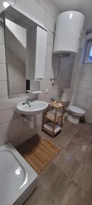 a bathroom with a sink and a toilet and a mirror at Apartman Mila Prnjavor in Prnjavor