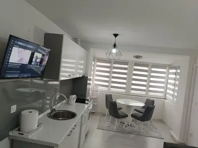 a kitchen with a table and chairs and a tv at Stan na dan in Visoko