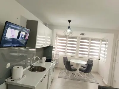 a kitchen with a table and chairs and a tv at Stan na dan in Visoko