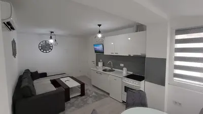a living room with a couch and a kitchen at Stan na dan in Visoko
