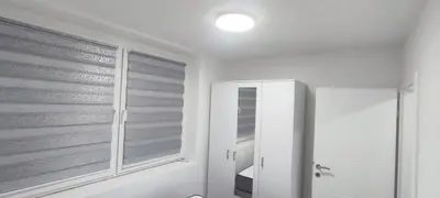 a white bathroom with a window and a mirror at Stan na dan in Visoko