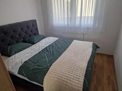 a bed in a small room with a window at Apartman Green Oaza in Doboj
