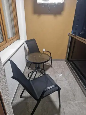 a table and chair in a room with a window at Apartman Green Oaza in Doboj