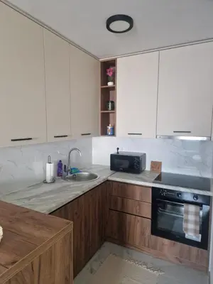 a kitchen with white cabinets and a sink at Apartman Green Oaza in Doboj