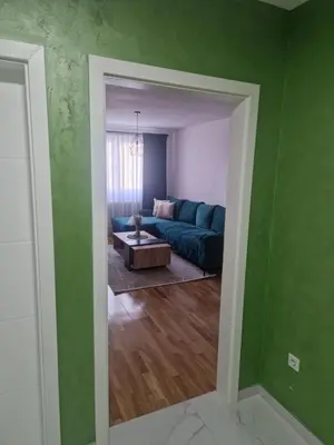 a living room with a blue couch and a table at Apartman Green Oaza in Doboj
