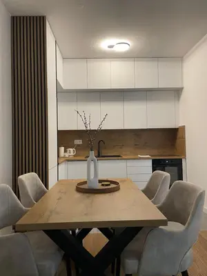 a dining room table with chairs and a vase on it at Apartman KK VII in Banja Luka