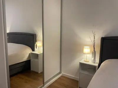 a mirror in a bedroom with a bed and a bed sqor at Apartman KK VII in Banja Luka