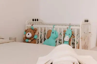 a crib with stuffed animals in a bedroom at Apartman CENTRAL LOFT Gradiška in Bosanska Gradiška
