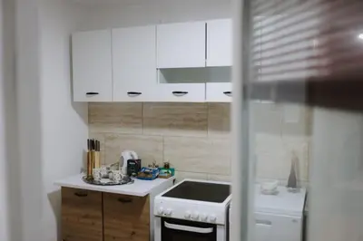 a kitchen with white cabinets and a stove top oven at Apartman CENTRAL LOFT Gradiška in Bosanska Gradiška