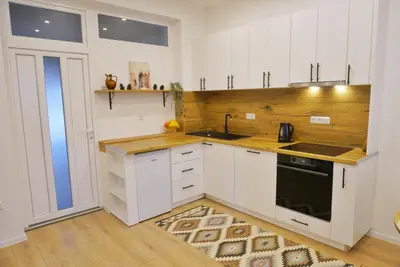 a kitchen with white cabinets and a sink at Apartman Anita in Kupres