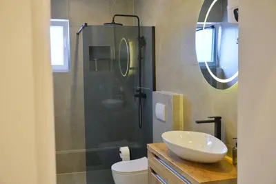 a bathroom with a sink and a glass shower at Apartman Anita in Kupres