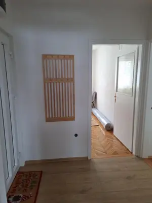 an empty room with a door and a wooden floor at Apartman Centar in Drvar