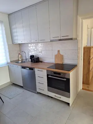 a kitchen with white cabinets and a stove top oven at Apartman Centar in Drvar