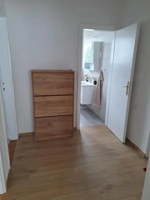 a bedroom with a dresser and a bathroom with a sink at Apartman Centar in Drvar
