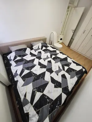 a bedroom with a black and white quilt on a bed at Apartman Magi in Prnjavor