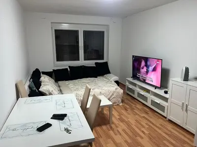 a living room with a bed and a table and a television at Apartman Ivano Kupres in Kupres