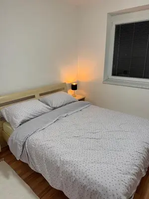 a bed in a bedroom with a window and a white bedspread at Apartman Ivano Kupres in Kupres