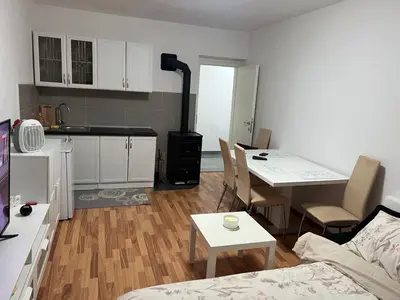 a kitchen and a living room with a table and chairs at Apartman Ivano Kupres in Kupres
