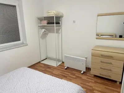 a bedroom with a bed and a dresser and a mirror at Apartman Ivano Kupres in Kupres