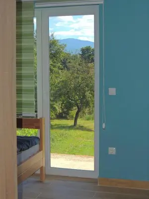 a door to a room with a view of a tree at Hostel Sobe Popović in Nova Bila