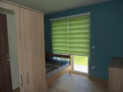 a bedroom with a window with green blinds at Hostel Sobe Popović in Nova Bila