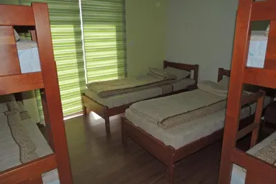 a room with three bunk beds and a window at Hostel Sobe Popović in Nova Bila