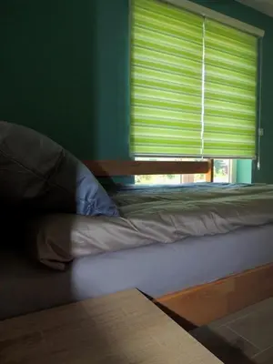 a bed sitting in a room with a window at Hostel Sobe Popović in Nova Bila
