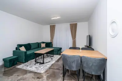 a living room with a green couch and a table at Apartmani Deluxe in Sanski most