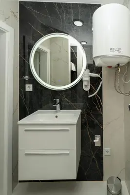 a bathroom with a white sink and a mirror at Apartmani Deluxe in Sanski most