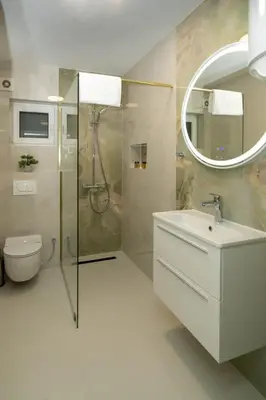 a bathroom with a shower and a sink and a mirror at Apartmani Deluxe in Sanski most