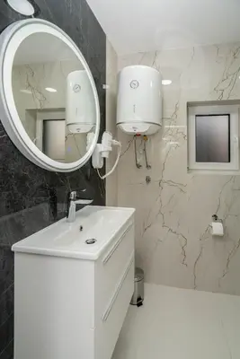 a bathroom with a white sink and a mirror at Apartmani Deluxe in Sanski most