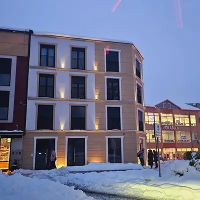 a large building with snow in front of it at VIP Apartman Friendly Home in Tuzla