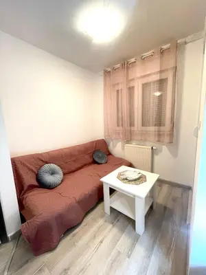 a living room with a red couch and a table at Studio 34 in Doboj