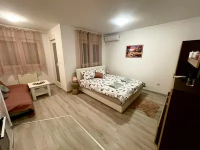 a small bedroom with a bed and a table at Studio 34 in Doboj