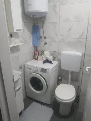 a bathroom with a washing machine and a toilet at Apartman Bato in Banja Luka