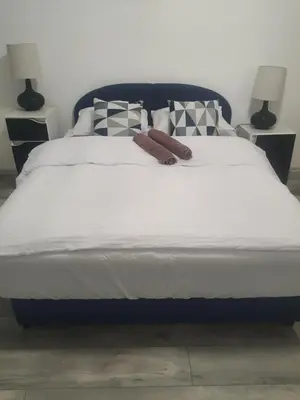 a large bed with white sheets and pillows at Apartman Bato in Banja Luka