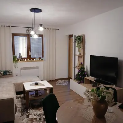 a living room with a couch and a tv at Apartman Montis in Kupres