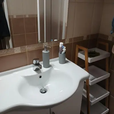 a bathroom with a white sink and a mirror at Apartman Montis in Kupres