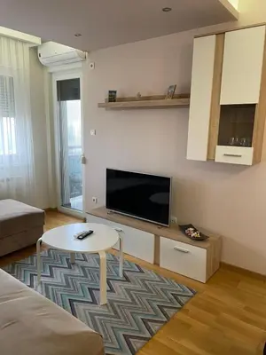 a living room with a flat screen tv and a table at Apartman Savanovic sa garazom in Banja Luka