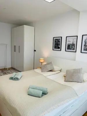 two beds in a white room with two pillows on them at Dinka Apartments Park Lake in Tuzla