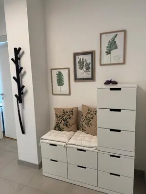 a bedroom with a white dresser and a couch at Dinka Apartments Park Lake in Tuzla