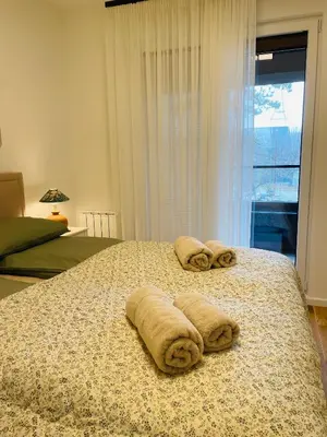 a bedroom with a bed with towels on it at Dinka Apartments Park Lake in Tuzla