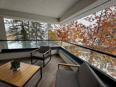 a room with a balcony with a table and chairs at Dinka Apartments Park Lake in Tuzla