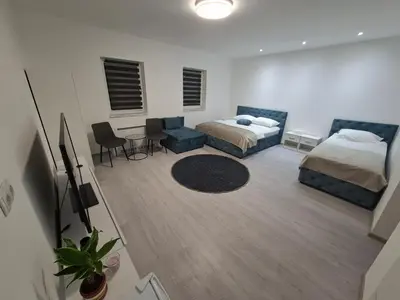 a bedroom with a bed and a couch and a table at Pansion Kod Brajlovica in Tuzla