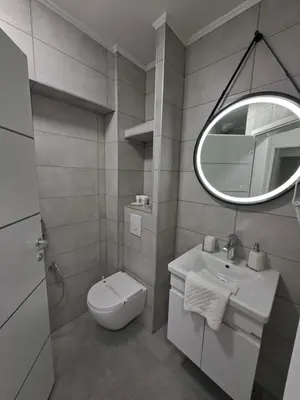 a bathroom with a toilet and a sink and a mirror at Pansion Kod Brajlovica in Tuzla