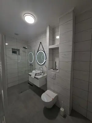 a bathroom with a toilet and a sink and a mirror at Pansion Kod Brajlovica in Tuzla