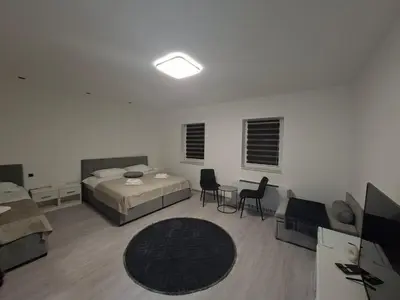 a bedroom with two beds and a table and chairs at Pansion Kod Brajlovica in Tuzla